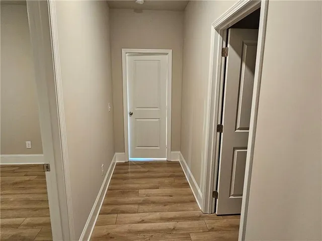 a view of a hallway with wooden floor and staircase