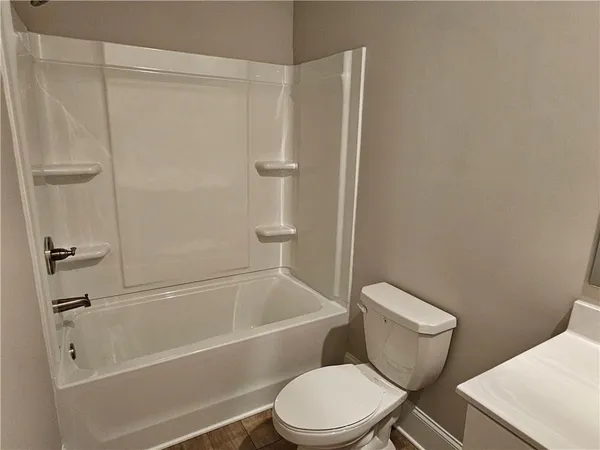 a white toilet and tub sitting next to a bathroom sink