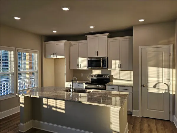 a kitchen with stainless steel appliances a microwave a sink and cabinets