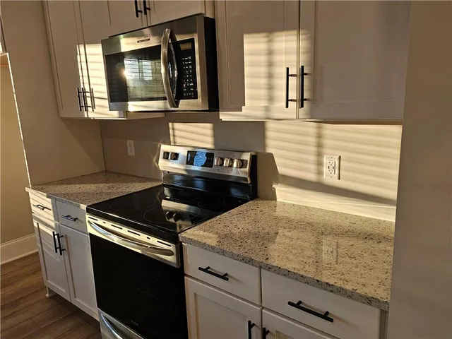 a kitchen with granite countertop a stove and a sink