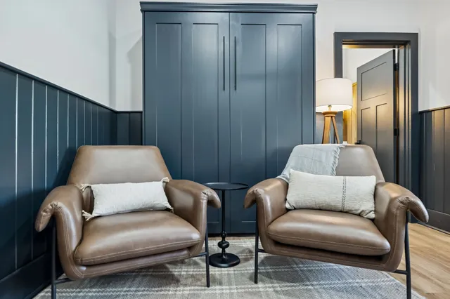 a dining room with furniture a chandelier and wooden floor