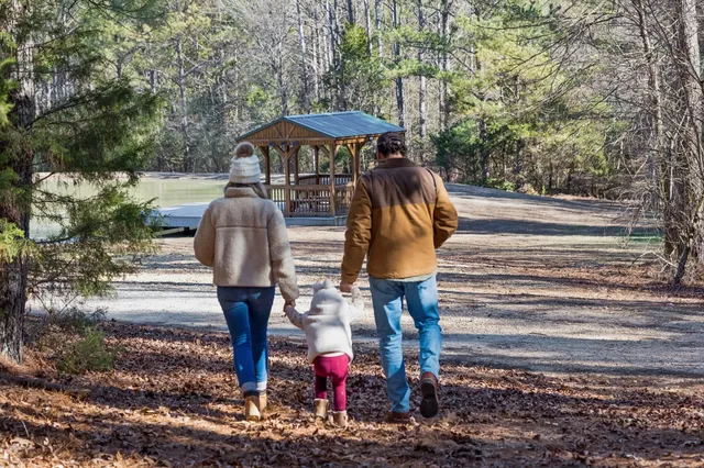 a view of a hallway with wooden floor and a refrigerator