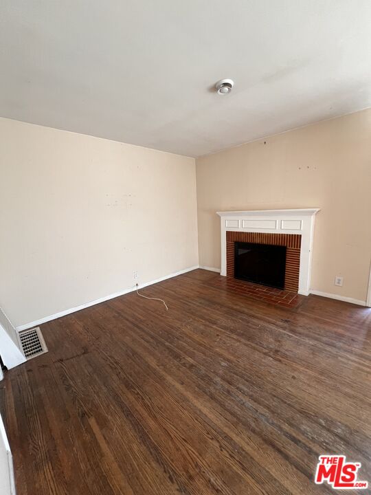 8903 Ramsgate Avenue Los Angeles, CA 90045 - Photo 5 of 15 a view of empty room with wooden floor and fireplace