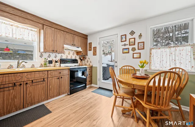 a kitchen with stainless steel appliances granite countertop a kitchen island a stove a table and chairs