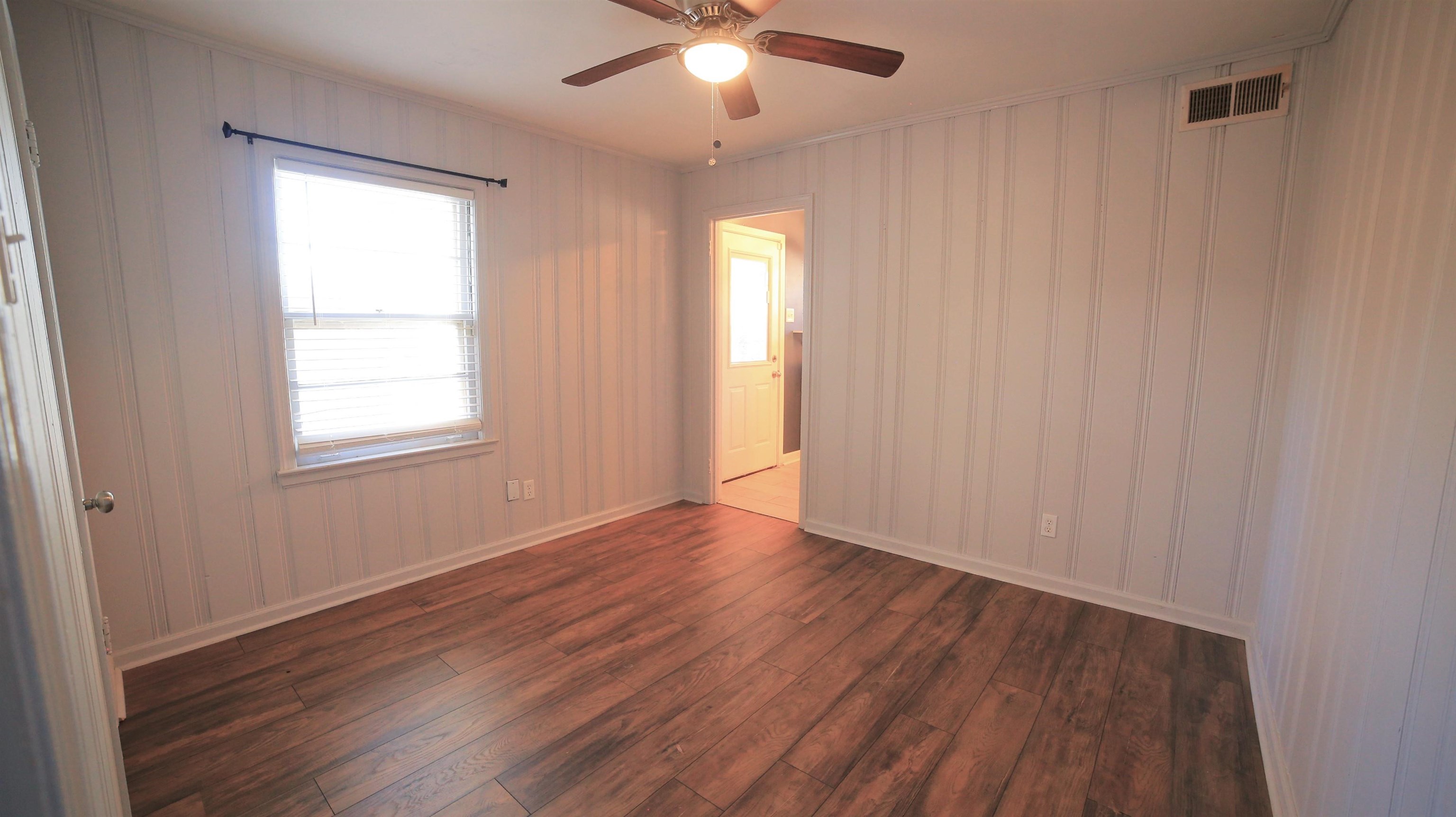 1605 Marcia Road Memphis, TN 38117 - Photo 11 of 15 a view of an empty room with wooden floor and a window
