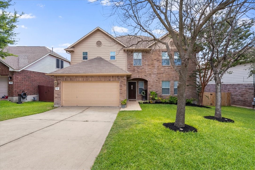 a front view of a house with a garden and trees