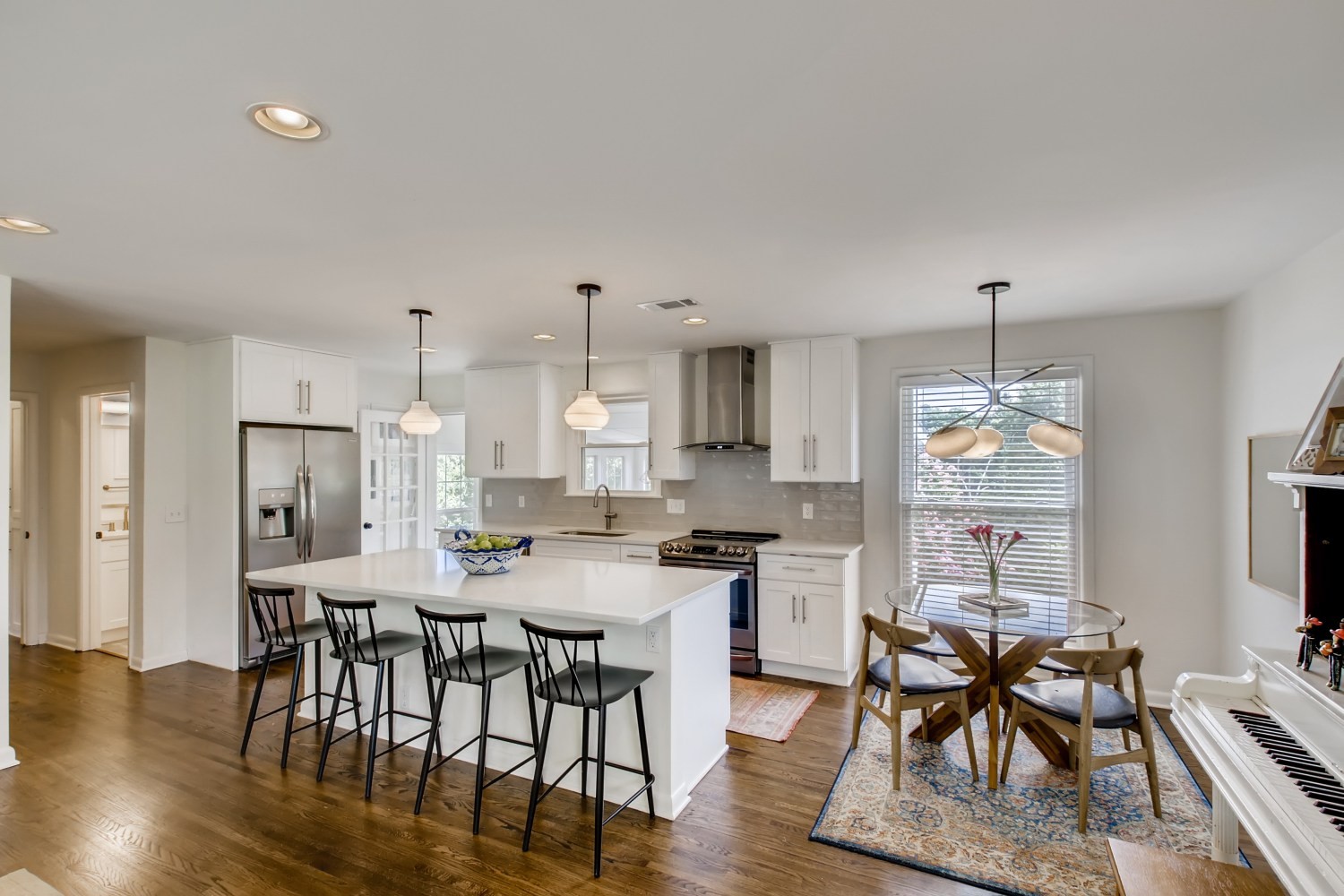 1005 A Mitchell Road Nashville, TN 37206 - Photo 5 of 23 a kitchen with stainless steel appliances kitchen island granite countertop a dining table chairs and white cabinets