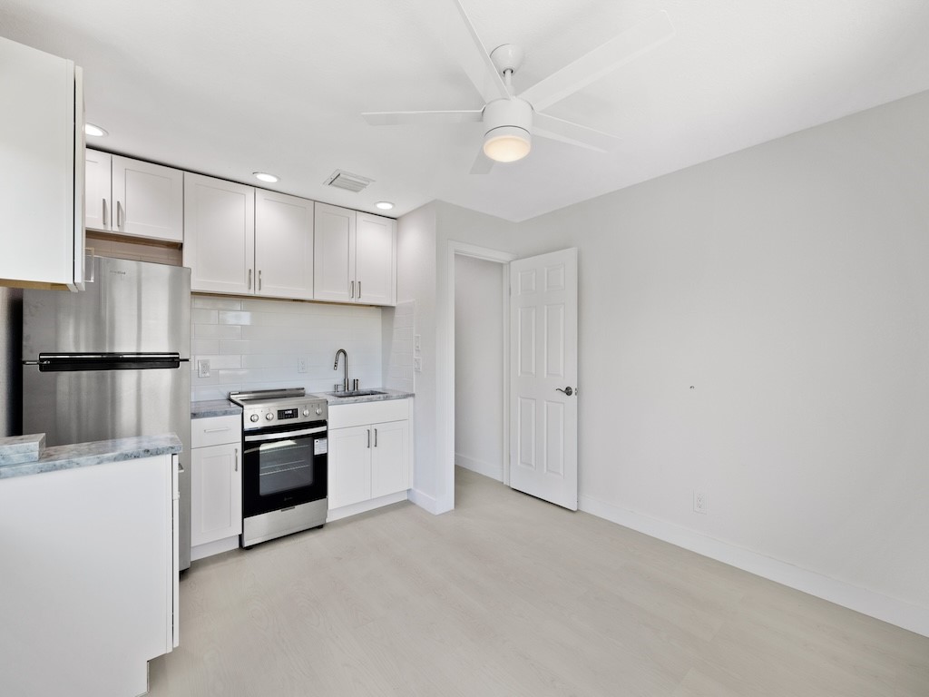 741 Hernando Street Fort Pierce, FL 34949 - Photo 11 of 36 a kitchen with granite countertop a refrigerator oven a sink and dishwasher