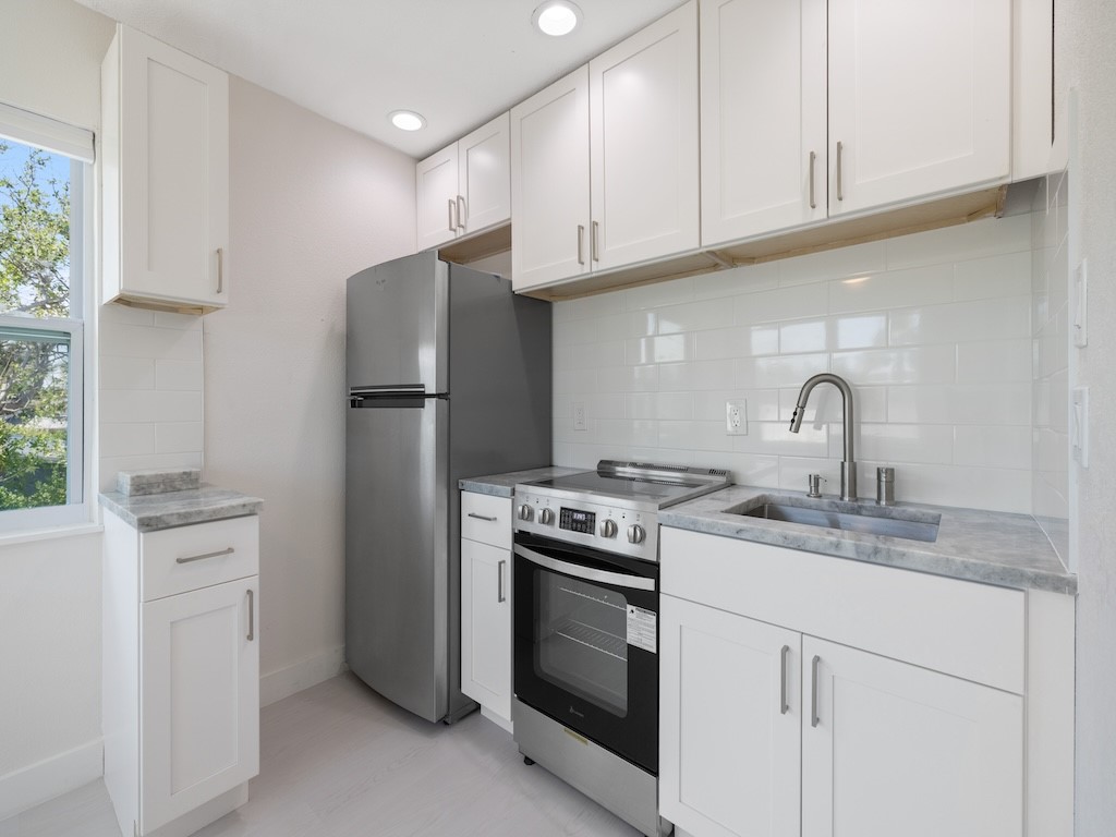 741 Hernando Street Fort Pierce, FL 34949 - Photo 14 of 36 a kitchen with appliances a sink and cabinets
