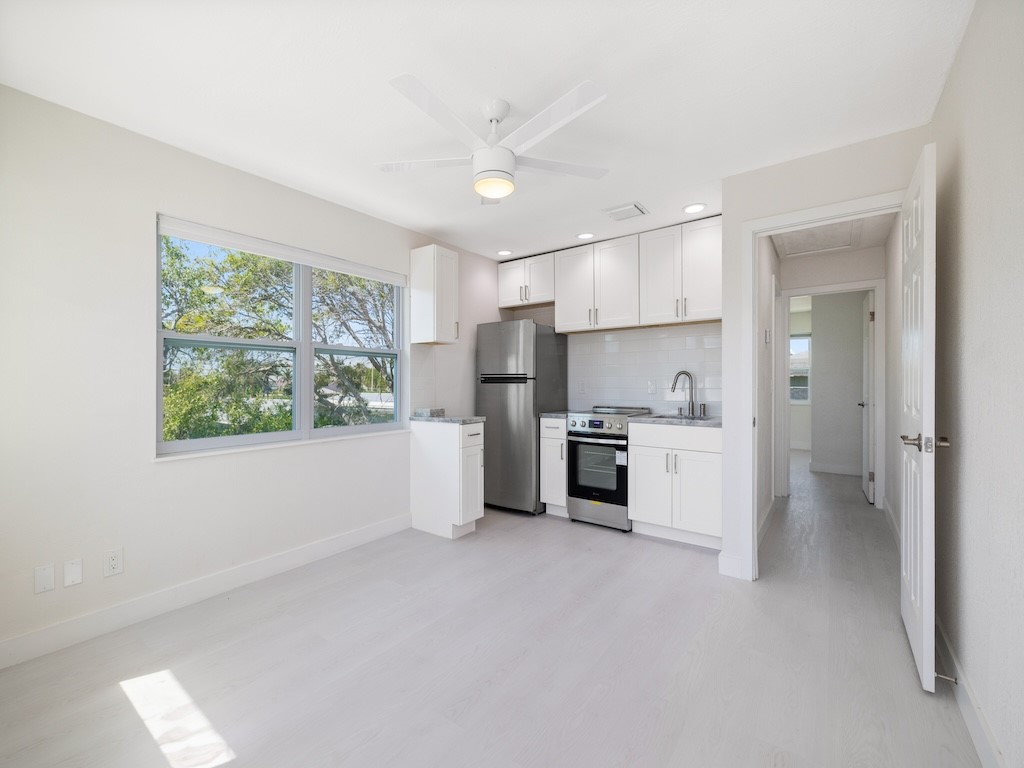 741 Hernando Street Fort Pierce, FL 34949 - Photo 16 of 36 a kitchen with white cabinets and stainless steel appliances