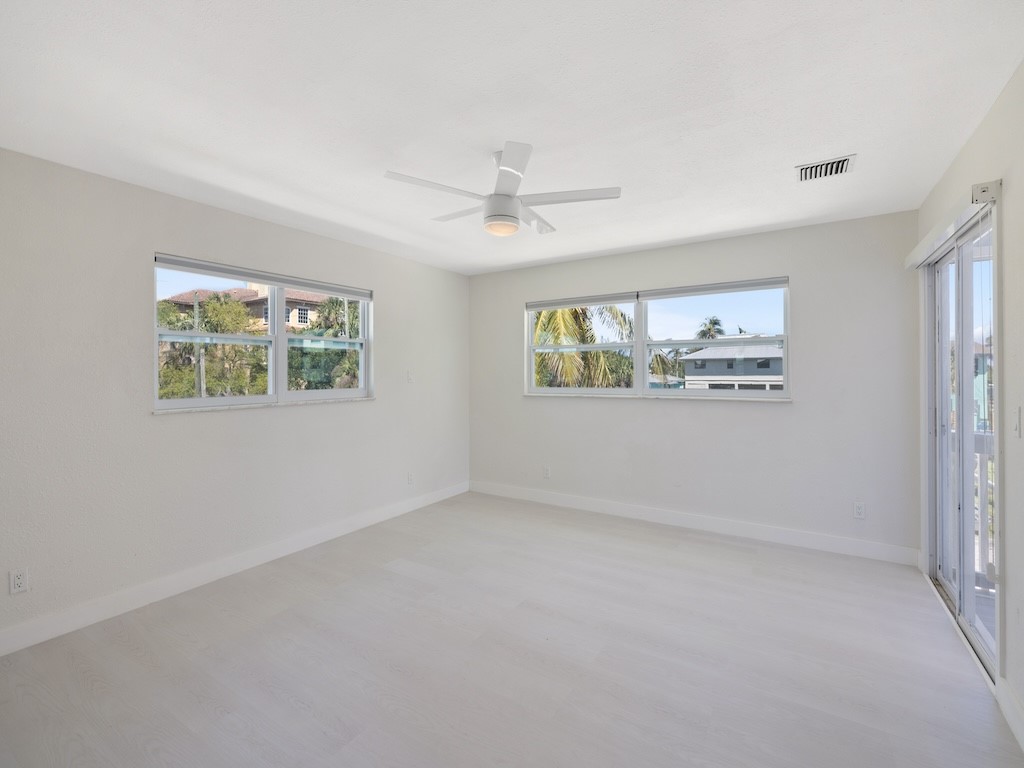 741 Hernando Street Fort Pierce, FL 34949 - Photo 21 of 36 an empty room with windows and ceiling fan