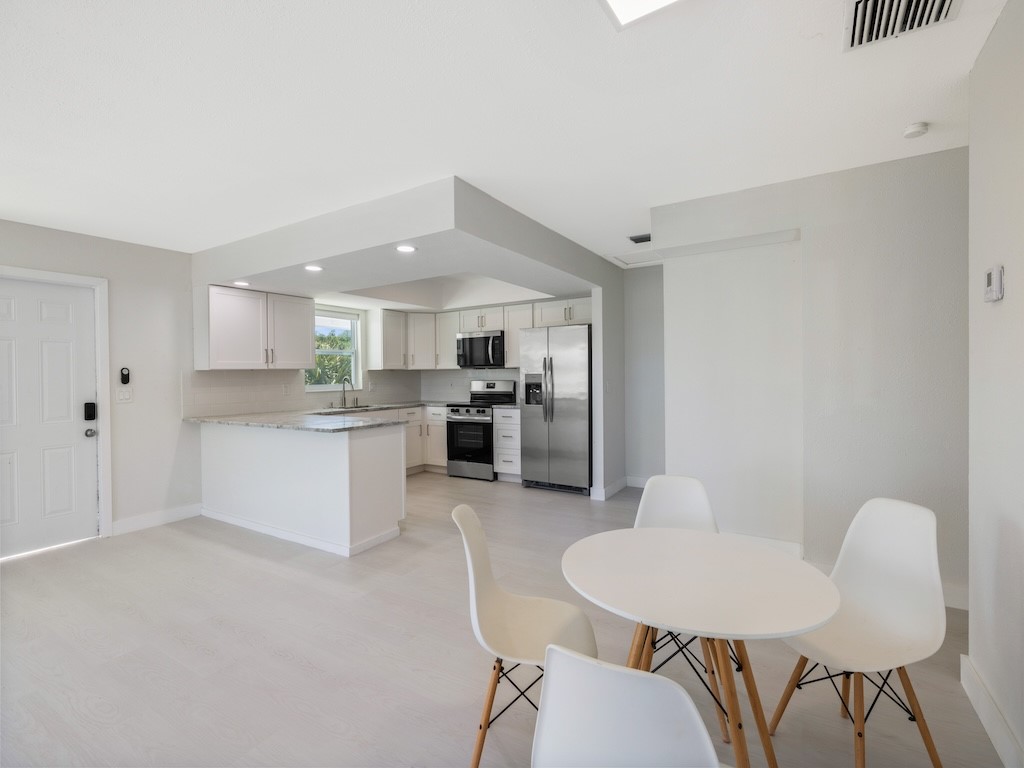 741 Hernando Street Fort Pierce, FL 34949 - Photo 29 of 36 a kitchen with stainless steel appliances granite countertop a white table and chairs
