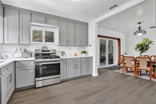 a kitchen with stainless steel appliances granite countertop a stove a sink and a refrigerator