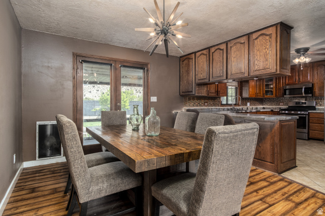 100 Third North Helper, UT 84526 - Photo 15 of 30 Dining area with wood-finish flooring, a rustic wood dining table, and direct access to the outdoor space through double glass-paneled doors