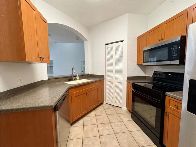 a kitchen with stainless steel appliances granite countertop a sink stove and microwave