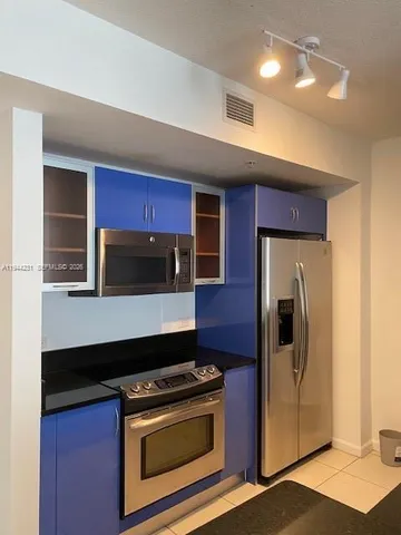 a kitchen with stainless steel appliances granite countertop a stove microwave and refrigerator