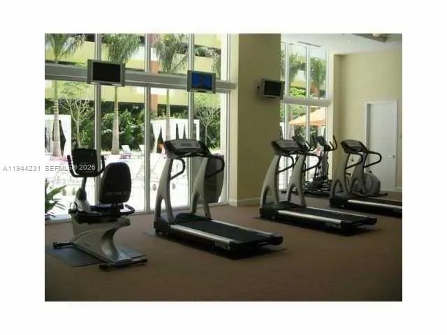 a room with gym equipment and large mirror