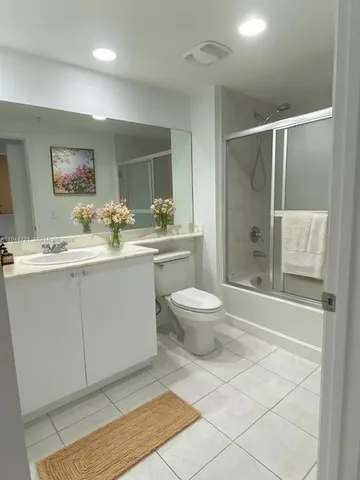a spacious bathroom with a granite countertop sink toilet and shower