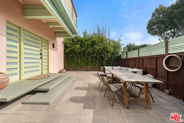 a backyard of a house with barbeque oven table and chairs
