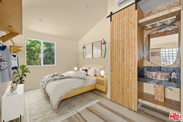 a bedroom with a bed next to a window