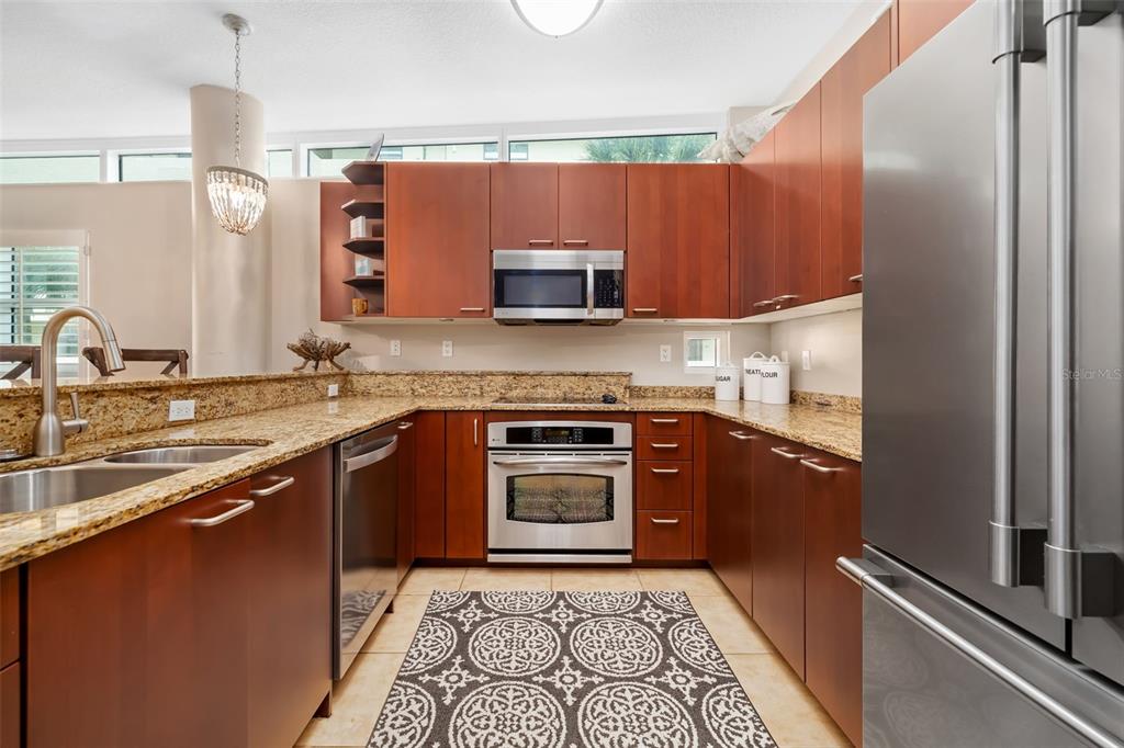 6512 Midnight Pass Road, Unit 204 Sarasota, FL 34242 - Photo 18 of 64 a kitchen with stainless steel appliances granite countertop a sink stove and refrigerator