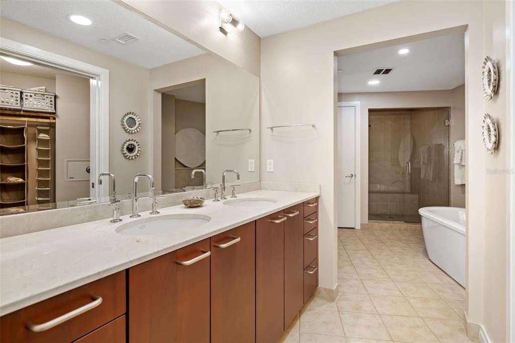 6512 Midnight Pass Road, Unit 204 Sarasota, FL 34242 - Photo 22 of 64 a spacious bathroom with a double vanity sink a large mirror and a bathtub
