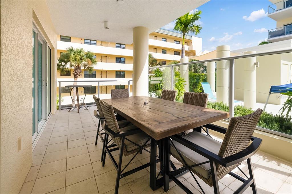 6512 Midnight Pass Road, Unit 204 Sarasota, FL 34242 - Photo 33 of 64 a view of a patio with a table and chairs