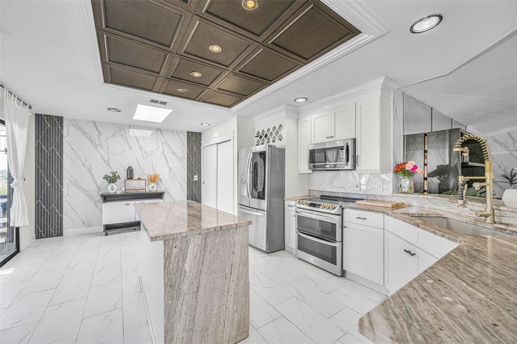 6009 Bayway Court New Port Richey, FL 34652 - Photo 17 of 93 a large white kitchen with a stove a sink dishwasher and a refrigerator with wooden floor