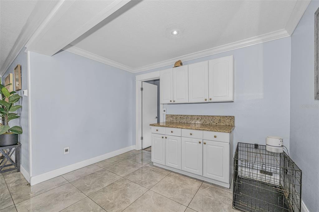 6009 Bayway Court New Port Richey, FL 34652 - Photo 53 of 93 a kitchen with granite countertop white cabinets and white appliances