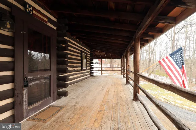 a living room with couches a fireplace with wooden floor