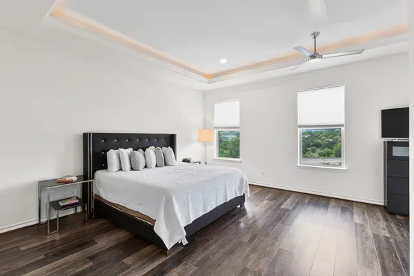 a large bedroom with a bed and wooden floor