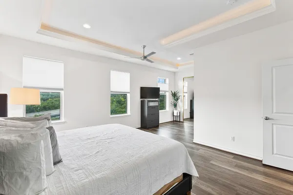 a bedroom with a large bed and a flat tv screen on dresser