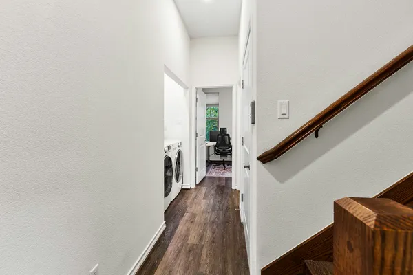 a view of a hallway with wooden floor and staircase