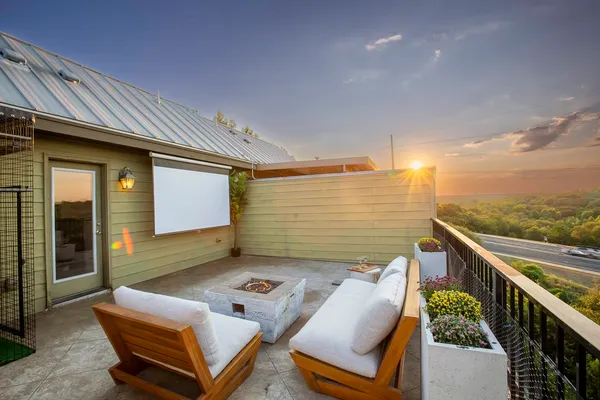 a roof deck with couches and potted plants