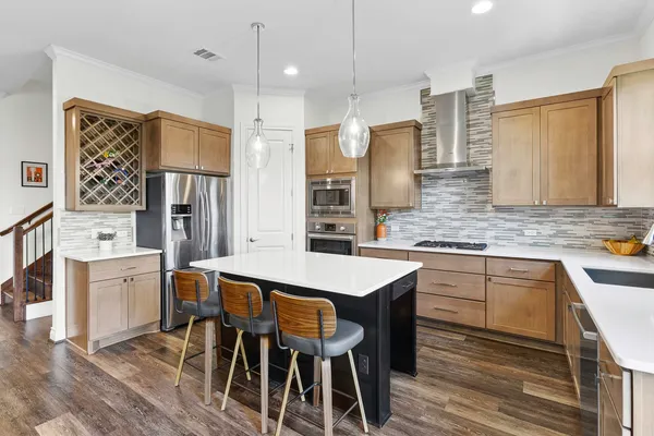 a kitchen with stainless steel appliances granite countertop a sink stove and refrigerator