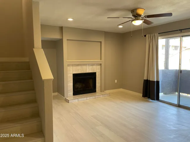 a view of a livingroom with a fireplace and a ceiling fan