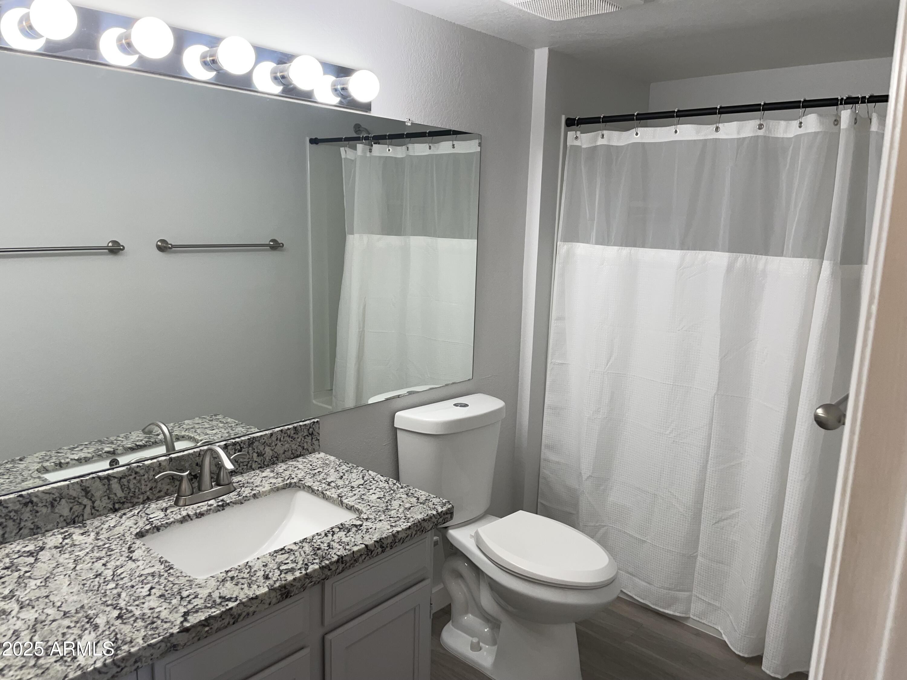 1645 West Baseline Road, Unit 2171 Mesa, AZ 85202 - Photo 4 of 11 a bathroom with a granite countertop sink toilet and shower