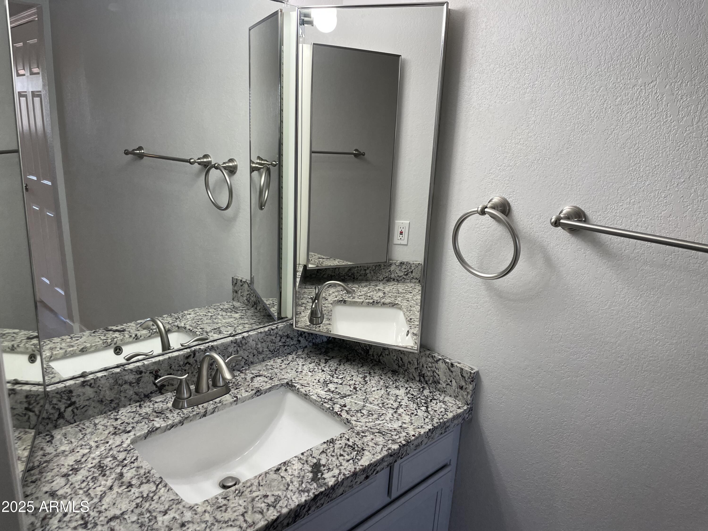 1645 West Baseline Road, Unit 2171 Mesa, AZ 85202 - Photo 5 of 11 a bathroom with a granite countertop sink and a mirror