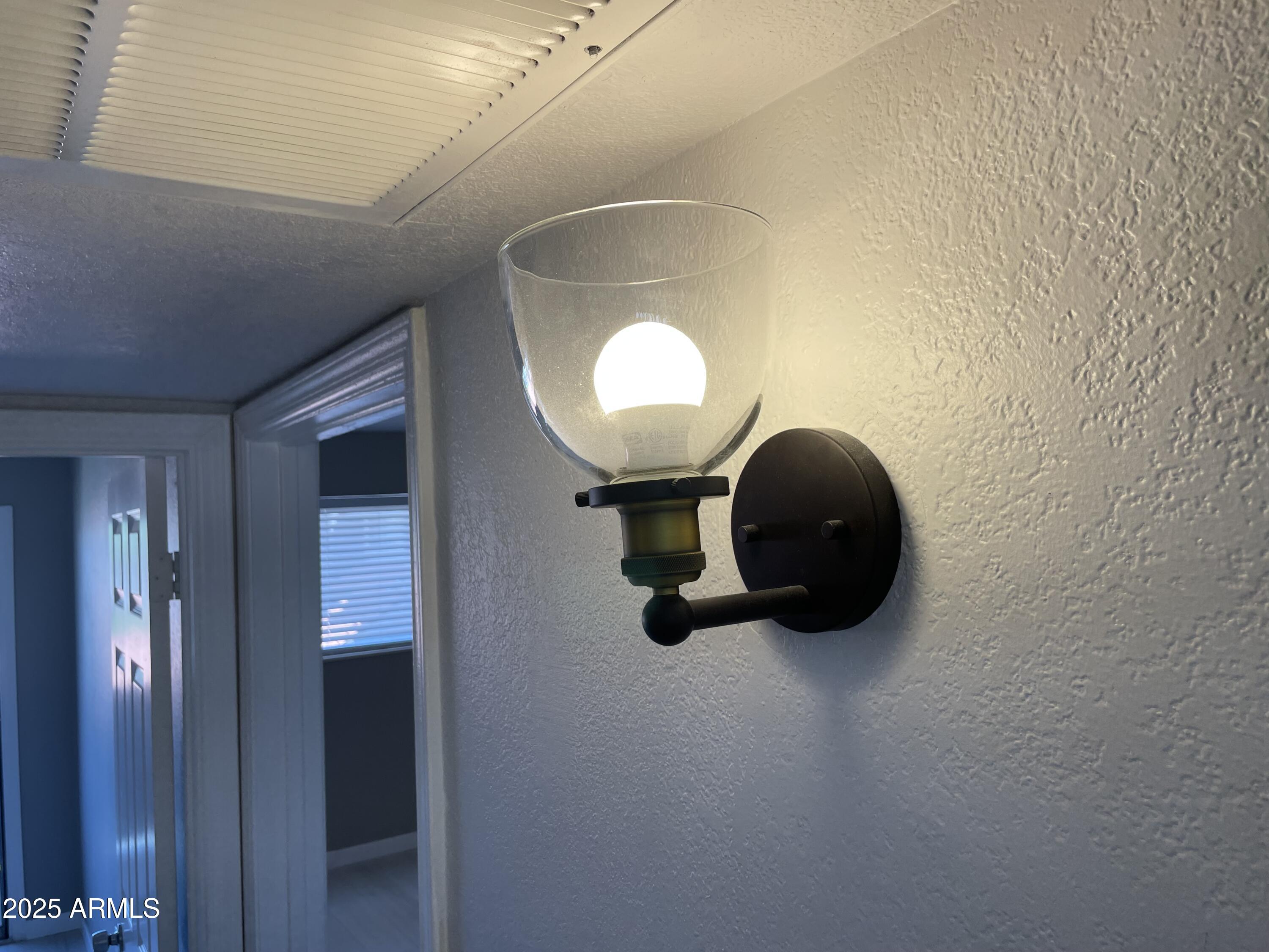 1645 West Baseline Road, Unit 2171 Mesa, AZ 85202 - Photo 6 of 11 a room with a mirror and a chandelier