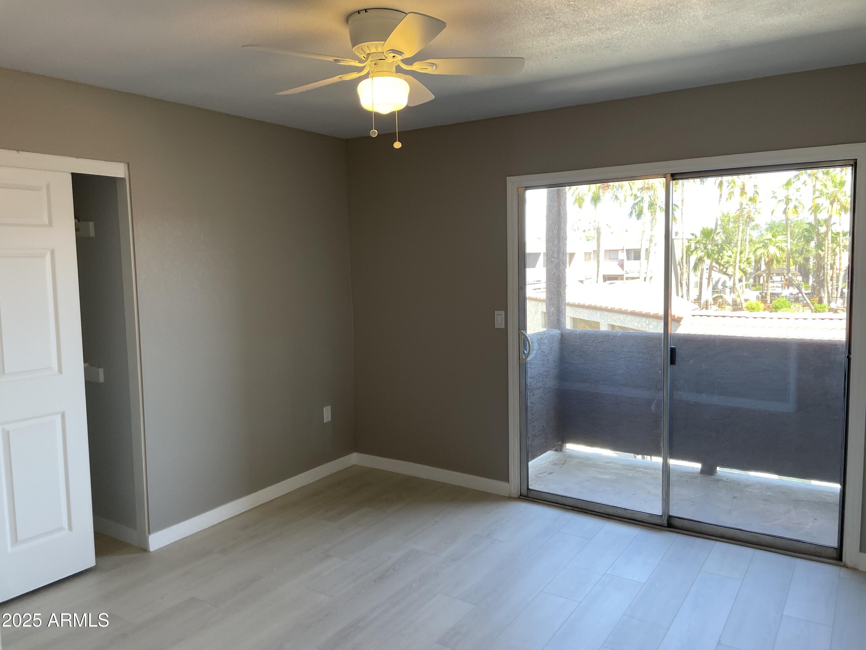 1645 West Baseline Road, Unit 2171 Mesa, AZ 85202 - Photo 7 of 11 an empty room with wooden floor and windows