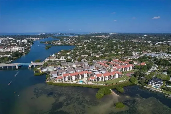 an aerial view of a city with lots of residential buildings ocean and mountain view in back