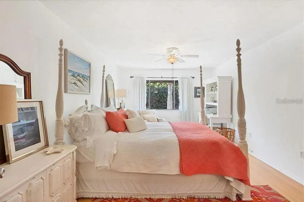 1650 Stickney Point Road, Unit 50202 Sarasota, FL 34231 - Photo 11 of 46 a bedroom with a large bed and a flat screen tv