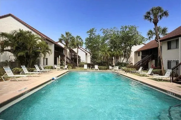 a view of a house with swimming pool and sitting area