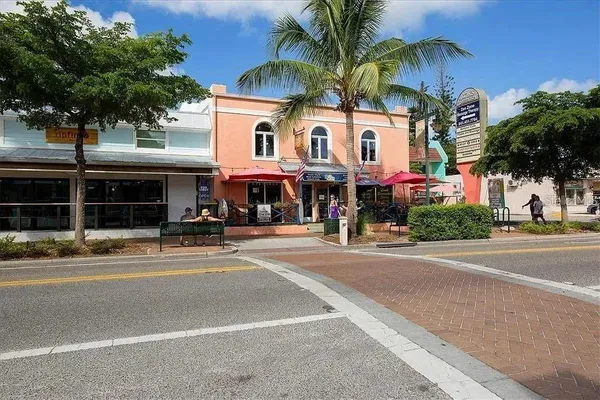 a view of a street with a building and trees in the background