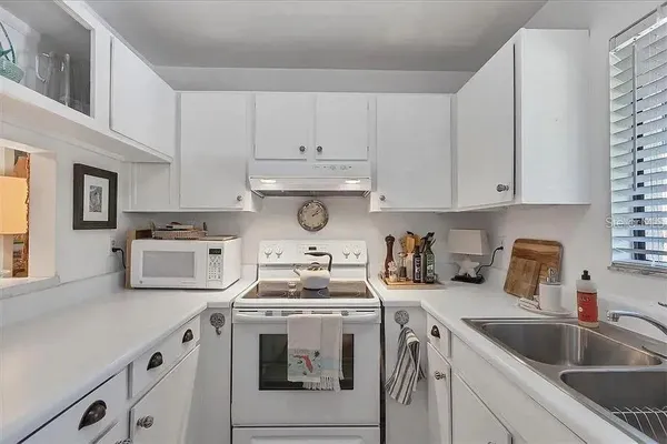 a kitchen with white cabinets and white appliances