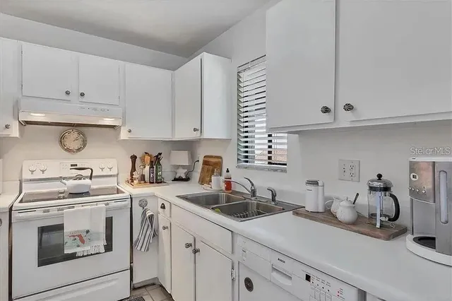 a kitchen with appliances a sink and cabinets
