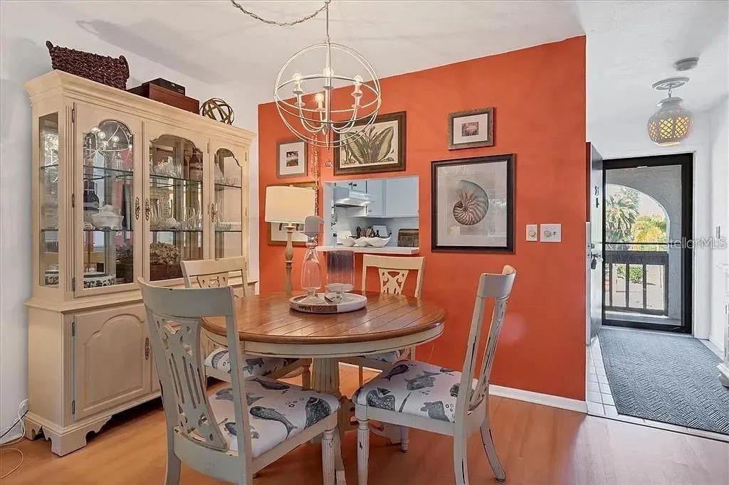 1650 Stickney Point Road, Unit 50202 Sarasota, FL 34231 - Photo 9 of 46 a view of a dining room with furniture large window and wooden floor