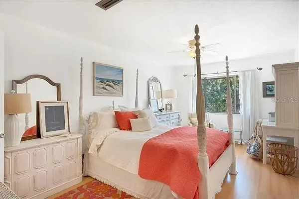 a bedroom with bed a night stand and a large window