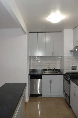 a kitchen with granite countertop a stove and a sink