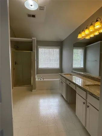 a bathroom with a tub sink and mirror